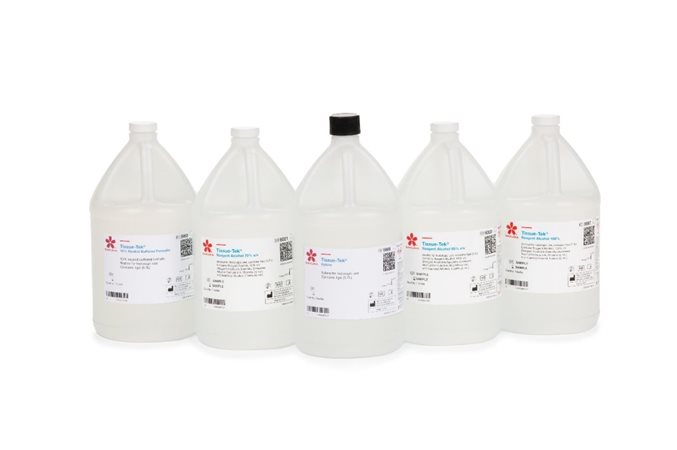 Five one-gallon plastic bottles with white labels, containing laboratory chemicals, are arranged in a row against a white background.