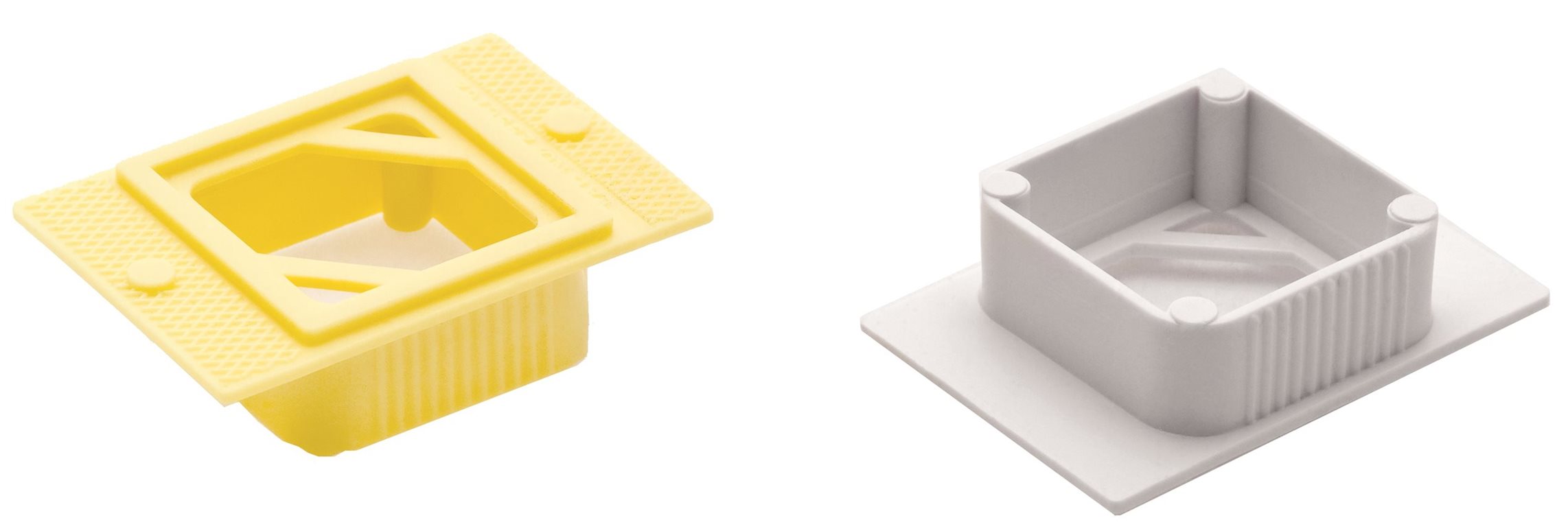 Two rectangular plastic objects, one yellow and one white, each with ridged sides and an open center featuring an angular cutout design.