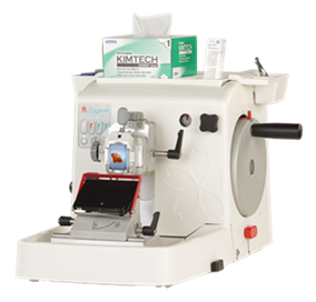 A laboratory microtome with a mounted tissue specimen, control knobs, and Kimtech wipes on top, used for preparing thin tissue sections for microscopy.