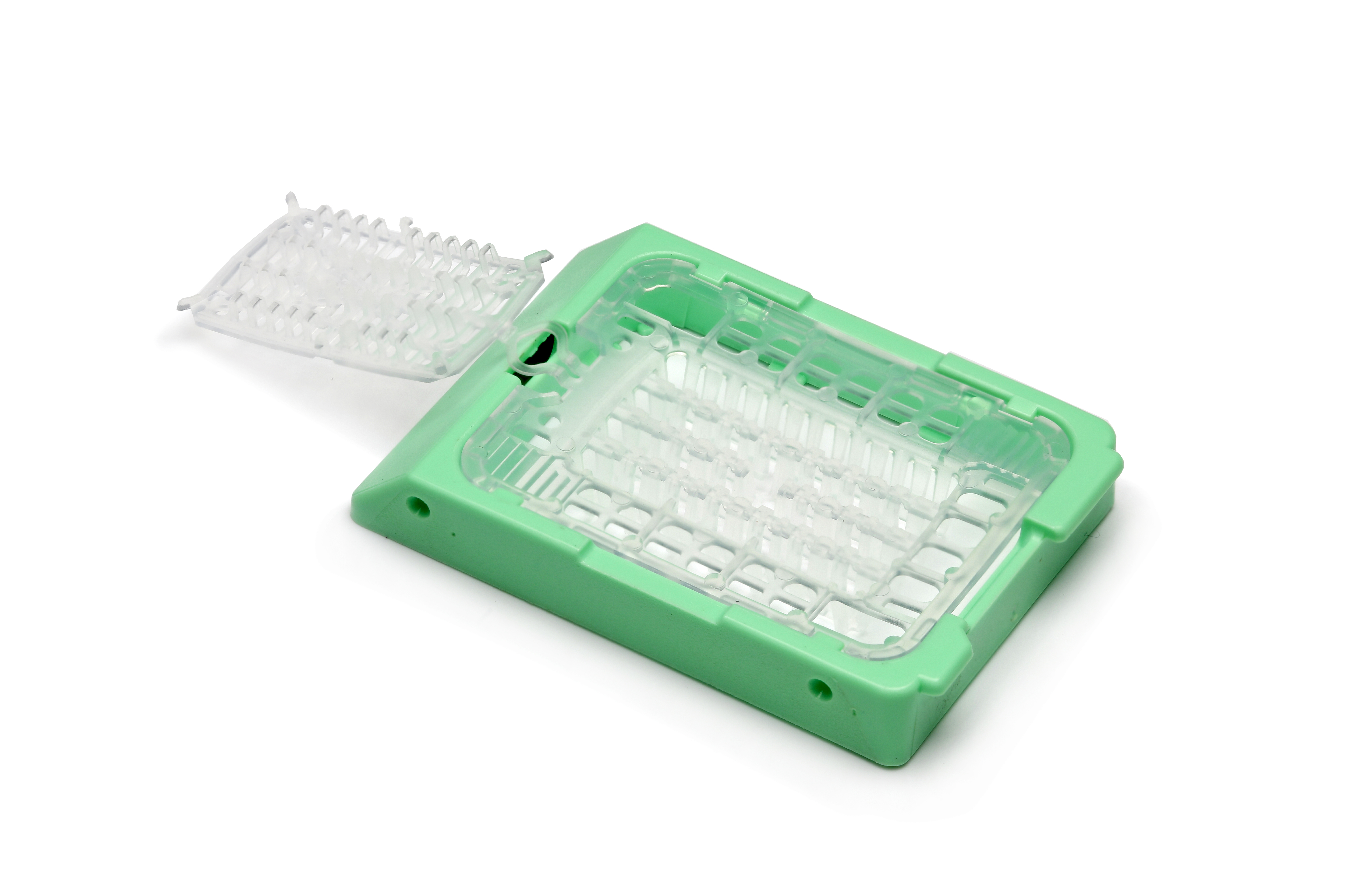 A green and clear plastic laboratory microplate with a hinged lid, shown open on a white background.