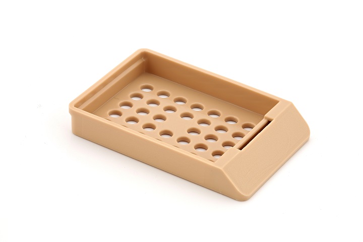 A rectangular, beige plastic tray with raised edges and multiple round holes in the base, set against a white background.