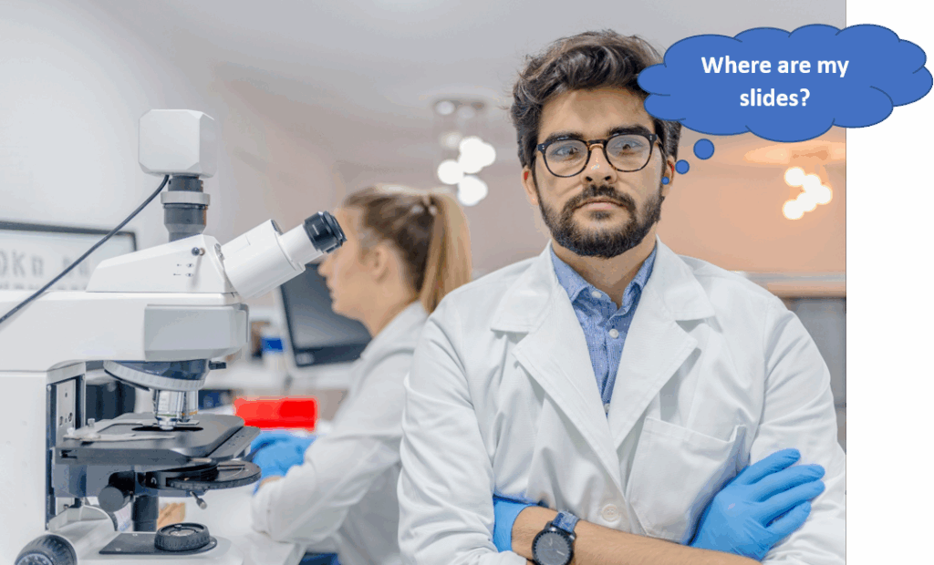 A male scientist in a lab coat stands by a microscope with arms crossed, while a female colleague works at a computer; a thought bubble reads, "Where are my slides?.