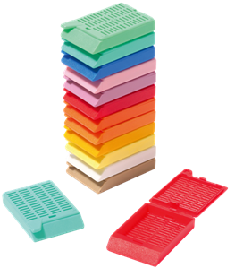 A stack of colorful plastic cassettes with vented lids, used for holding and processing tissue samples in laboratories. Two cassettes are shown open and separate from the stack.
