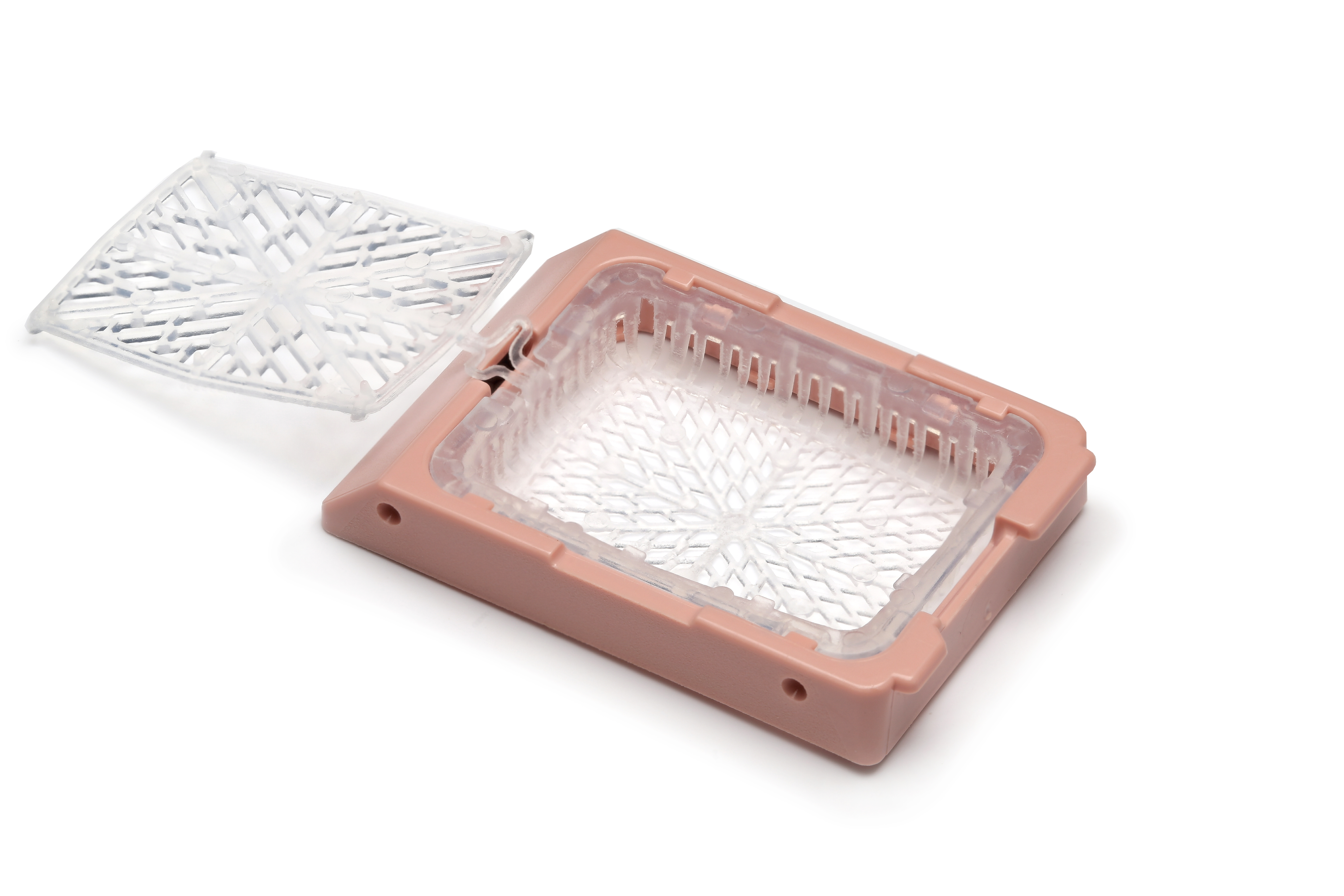 A pink and clear plastic tissue cassette with an open hinged lid, used for holding biological samples in laboratories, on a white background.