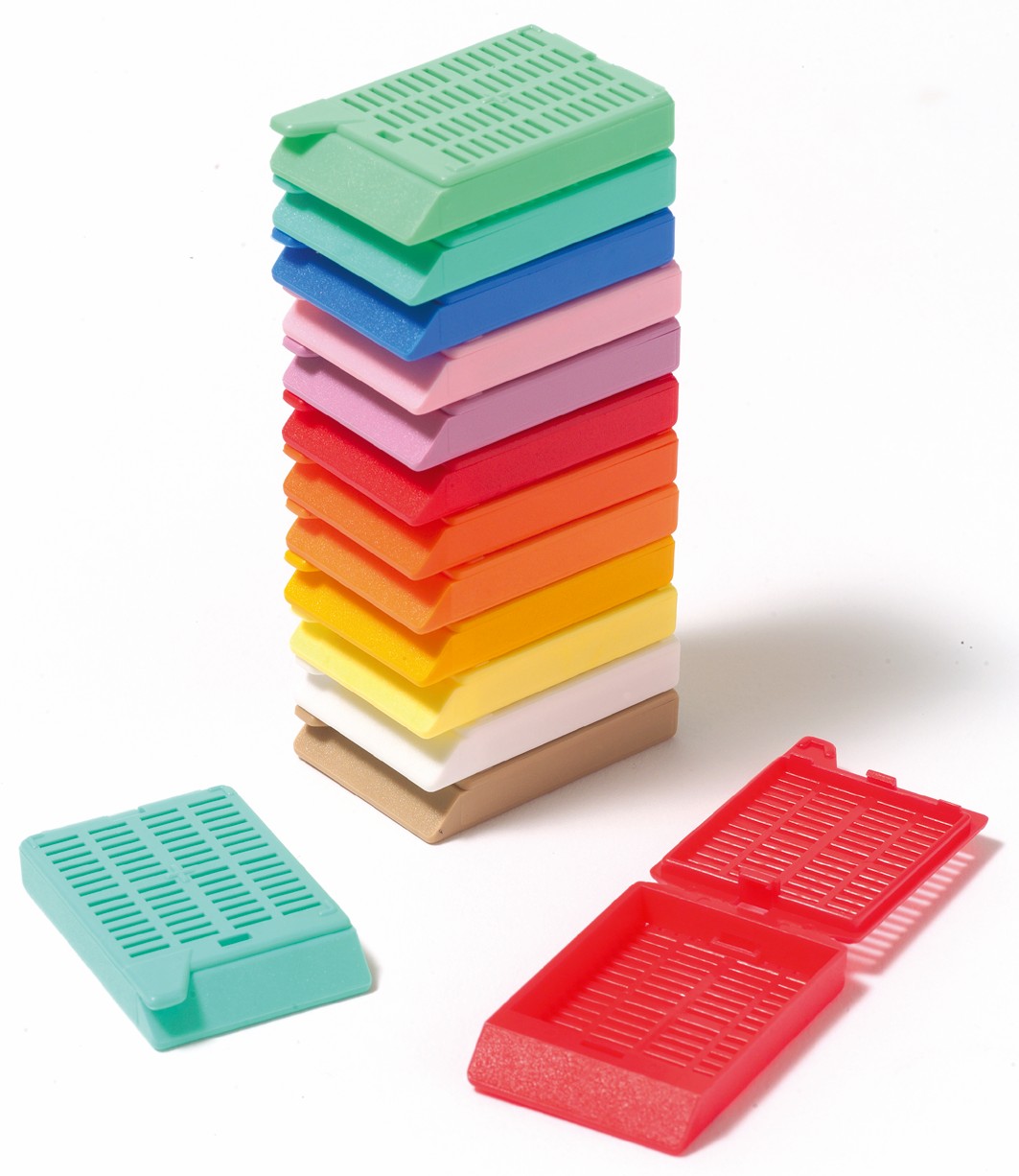 A stack of multicolored plastic cassettes is shown with three additional cassettes, one teal and two red, lying separately in front.