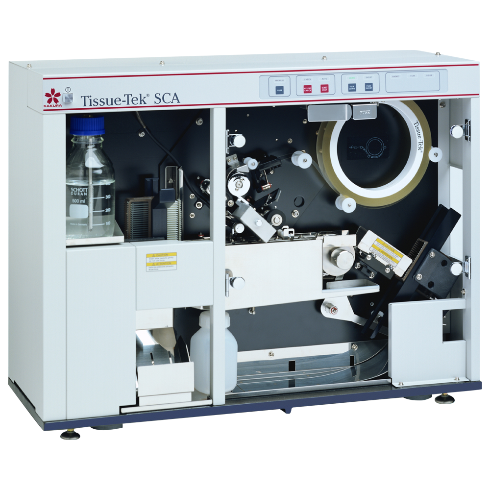 A laboratory tissue sectioning machine, partially open to show internal components including a bottle, tape reel, and rollers, labeled 