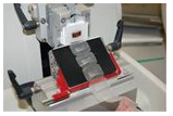 Microtome slicing thin sections of tissue for microscopic analysis, with tissue ribbon visible on the blade stage.